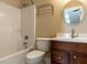 Well-lit bathroom with a white tub, toilet, vanity and wood cabinets at 106 White Deer Trl, Garner, NC 27529