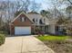 Charming brick home with a manicured lawn, attached garage, and inviting curb appeal on a sunny day at 106 White Deer Trl, Garner, NC 27529