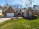 Charming brick home with a manicured lawn, attached garage, and inviting curb appeal on a sunny day at 106 White Deer Trl, Garner, NC 27529