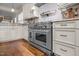 Close up of a stainless steel oven and cooktop, surrounded by custom cabinets and granite countertops at 1086 Tender Dr, Apex, NC 27502