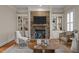 Cozy living room featuring a stone fireplace, built-in bookshelves, and comfortable seating at 1086 Tender Dr, Apex, NC 27502