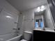Bathroom features a white shower-tub combo, toilet, and single sink vanity at 1104 Thelonious Dr, Raleigh, NC 27610