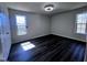 Bright bedroom featuring modern dark wood flooring and two sunny windows at 1104 Thelonious Dr, Raleigh, NC 27610