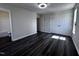 This bedroom features dark wood floors, a modern light fixture, and closet space with ample storage opportunities at 1104 Thelonious Dr, Raleigh, NC 27610