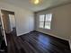 A bright bedroom with dark floors, a window for natural light, and a closet at 1104 Thelonious Dr, Raleigh, NC 27610