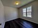 This bedroom features dark wood floors and a large window with natural light at 1104 Thelonious Dr, Raleigh, NC 27610