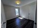 Bedroom with dark wood floors, a window letting in natural light, and a closet provides storage at 1104 Thelonious Dr, Raleigh, NC 27610