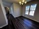Bright dining room featuring modern dark wood flooring and a view to hallway at 1104 Thelonious Dr, Raleigh, NC 27610