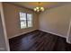 Bright dining room featuring modern dark wood flooring and a charming chandelier at 1104 Thelonious Dr, Raleigh, NC 27610