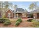 Beautiful backyard with a brick patio, elegant water feature, and lush landscaping creating a private retreat at 112 Trellingwood Dr, Morrisville, NC 27560