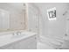 Bright bathroom featuring a skylight over the tub, enhancing natural light and highlighting the clean, white tile at 112 Trellingwood Dr, Morrisville, NC 27560