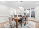 Dining room features a wooden table, gray chairs, and a modern chandelier for a stylish ambiance at 112 Trellingwood Dr, Morrisville, NC 27560