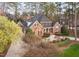 Stately brick home features manicured landscaping, mature trees, and a circular driveway at 112 Trellingwood Dr, Morrisville, NC 27560