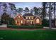 Traditional brick home featuring a manicured lawn, mature trees, and manicured landscaping at 112 Trellingwood Dr, Morrisville, NC 27560
