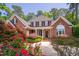 Charming two-story brick home featuring a manicured lawn and beautiful landscaping at 112 Trellingwood Dr, Morrisville, NC 27560