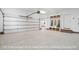 A bright garage featuring a roll-up door, hall tree, and an entrance to the home at 112 Trellingwood Dr, Morrisville, NC 27560