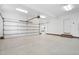 Well-lit garage with white epoxy flooring and brick trim, offering ample space for parking and storage at 112 Trellingwood Dr, Morrisville, NC 27560