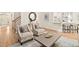 Cozy living room with hardwood floors, patterned chairs, and an open floor plan to the kitchen at 112 Trellingwood Dr, Morrisville, NC 27560