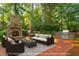 Relaxing outdoor patio area with stone fireplace, grilling area, and comfortable seating for entertaining at 112 Trellingwood Dr, Morrisville, NC 27560