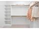 Bright walk-in closet with built-in shelving, wooden rods, and plush carpet at 112 Trellingwood Dr, Morrisville, NC 27560