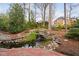 Backyard water feature with small waterfall flowing into a pond, surrounded by natural stone at 112 Trellingwood Dr, Morrisville, NC 27560