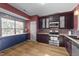 Kitchen with dark cabinets, stainless steel appliances, and wood-look floors at 116 Anterbury Dr, Apex, NC 27502