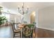Bright dining room features a round wooden table with seating for four, chandelier, and beautiful hardwood floors at 138 Tressel Way, Durham, NC 27707