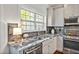 Bright kitchen featuring stainless steel appliances, granite counters, tile backsplash and a stainless steel sink at 138 Tressel Way, Durham, NC 27707