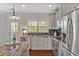 Well-lit kitchen with stainless steel appliances, gray cabinetry, and granite counters, with a view to the outside at 138 Tressel Way, Durham, NC 27707