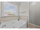 Oversized bathtub boasting neutral colored tiles and a large window at 1408 Harvey Johnson Rd, Raleigh, NC 27603