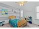 bedroom with a ceiling fan, dinosaur decor, a blue and grey striped accent wall, and shelving at 1408 Harvey Johnson Rd, Raleigh, NC 27603