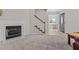 Light-filled living room with staircase, fireplace, and view into dining room beyond at 1408 Harvey Johnson Rd, Raleigh, NC 27603