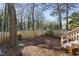 Fenced backyard with steps leading to upper deck and lots of shade trees at 1515 Edgeside Ct, Raleigh, NC 27609