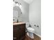Cozy half bathroom featuring a vanity with a dark wood cabinet and a round mirror at 1515 Edgeside Ct, Raleigh, NC 27609