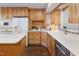 Well-equipped kitchen boasts wooden cabinets, white counters, and stainless steel appliances at 1515 Edgeside Ct, Raleigh, NC 27609