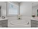 Bright bathroom featuring soaking tub and neutral gray walls at 1564 Highpoint St, Wake Forest, NC 27587