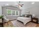 Spacious bedroom with a large window, ceiling fan, and hardwood floors at 1564 Highpoint St, Wake Forest, NC 27587