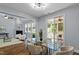 Open-concept dining room offering a glass table, access to a porch, hardwood floors, and a modern light fixture at 1564 Highpoint St, Wake Forest, NC 27587