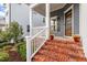 Inviting front porch with brick steps, decorative flowers, and a charming entrance to the home at 1564 Highpoint St, Wake Forest, NC 27587