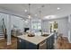 Open concept kitchen with a large island, stainless sink, and easy access to living and dining areas at 1564 Highpoint St, Wake Forest, NC 27587