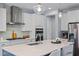 Kitchen features an island, stainless steel appliances, marble countertops, tile backsplash and white cabinets at 1564 Highpoint St, Wake Forest, NC 27587