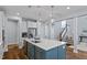 Large kitchen island with stainless sink, white cabinets, stainless appliances, and modern pendant lighting at 1564 Highpoint St, Wake Forest, NC 27587