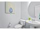 Powder room featuring pedestal sink, round mirror and blue floral wall art at 1564 Highpoint St, Wake Forest, NC 27587