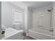 Bathroom with a tub/shower combo, vinyl floors, and a window at 1855 W West River Rd, Franklinton, NC 27525