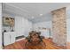A cozy dining area features a small table with barstool seating, set against a brick wall and wooden floors at 1855 W West River Rd, Franklinton, NC 27525