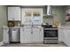 This kitchen offers stainless steel appliances, white cabinets, and ample natural light at 1855 W West River Rd, Franklinton, NC 27525