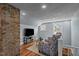 Bright living space with exposed brick, modern patterned chairs, and hardwood floors, perfect for relaxation and entertainment at 1855 W West River Rd, Franklinton, NC 27525