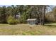 Outdoor storage shed in backyard surrounded by trees and grassy yard at 1855 W West River Rd, Franklinton, NC 27525