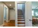 Open view of wooden stairs leading to the upper level, adjacent to a cozy bedroom with light blue walls at 1855 W West River Rd, Franklinton, NC 27525