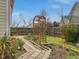 Landscaped backyard featuring a stone paver path, garden beds, and wooden arbor at 200 Indian Branch Dr, Morrisville, NC 27560